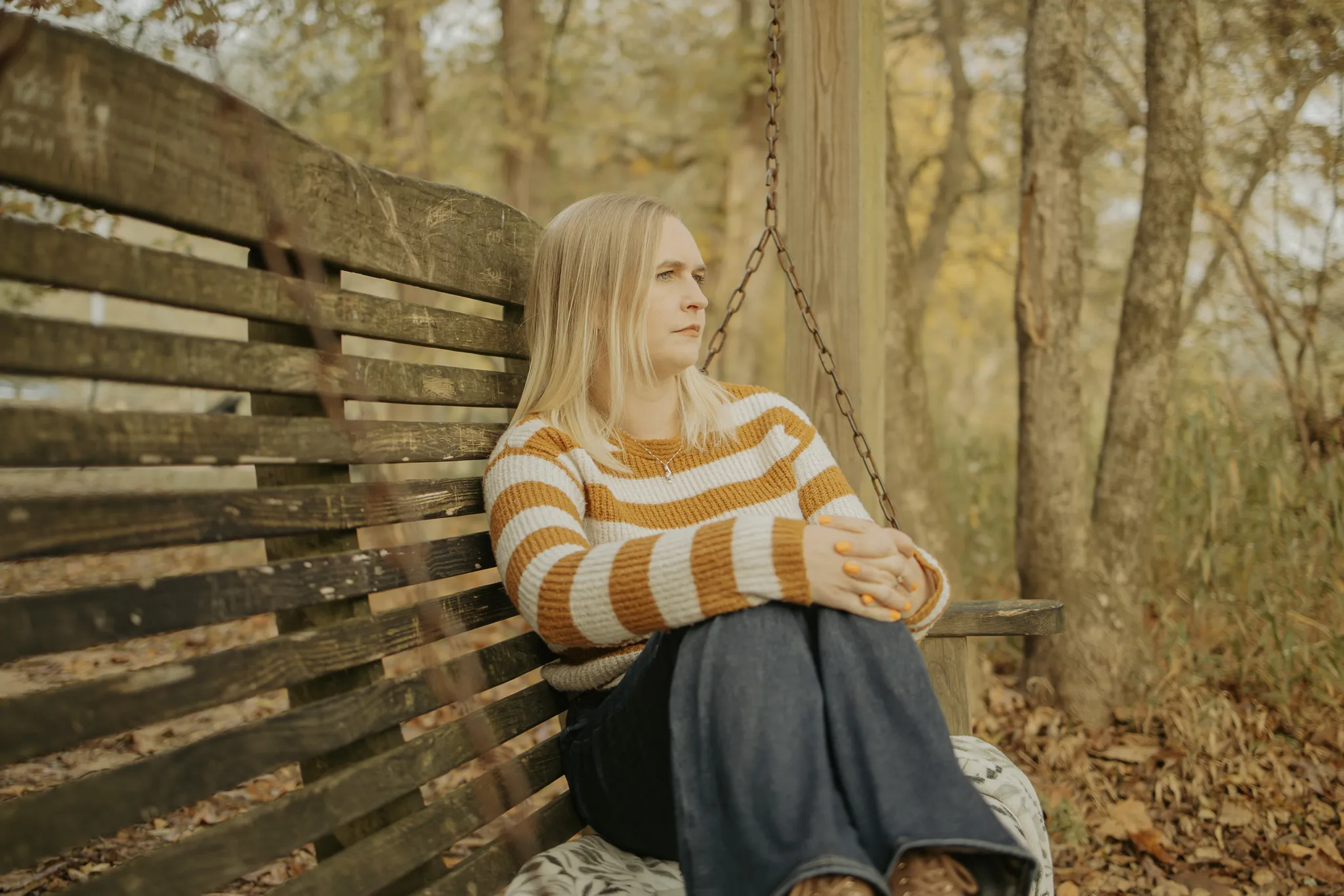 Woman sitting in swinging chair looking out over the river