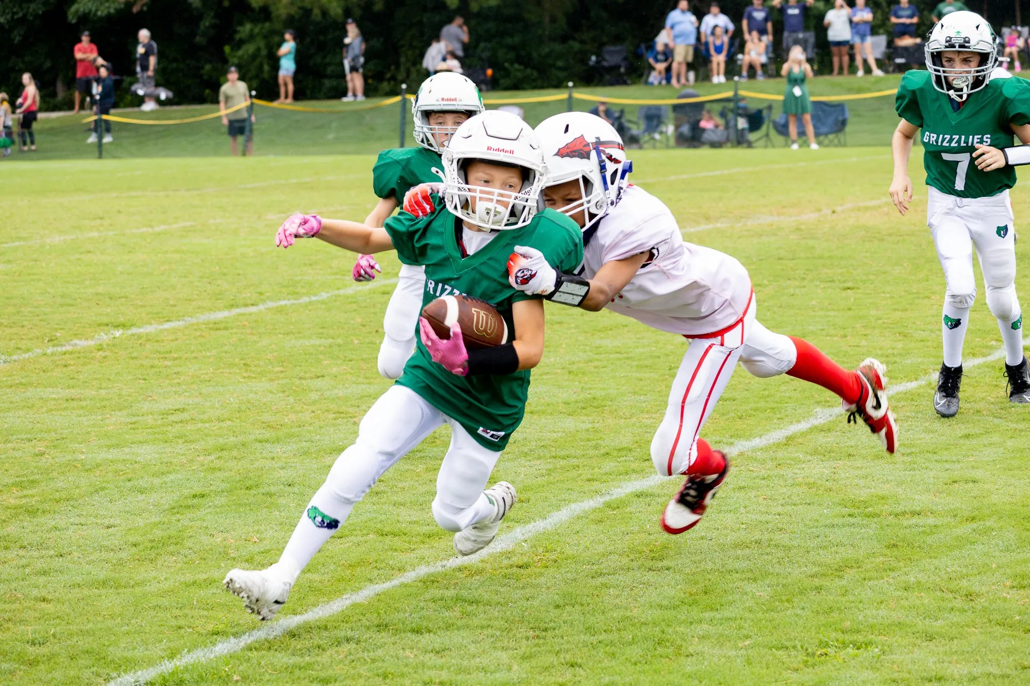 Football player running with a football at the start of a tackle
