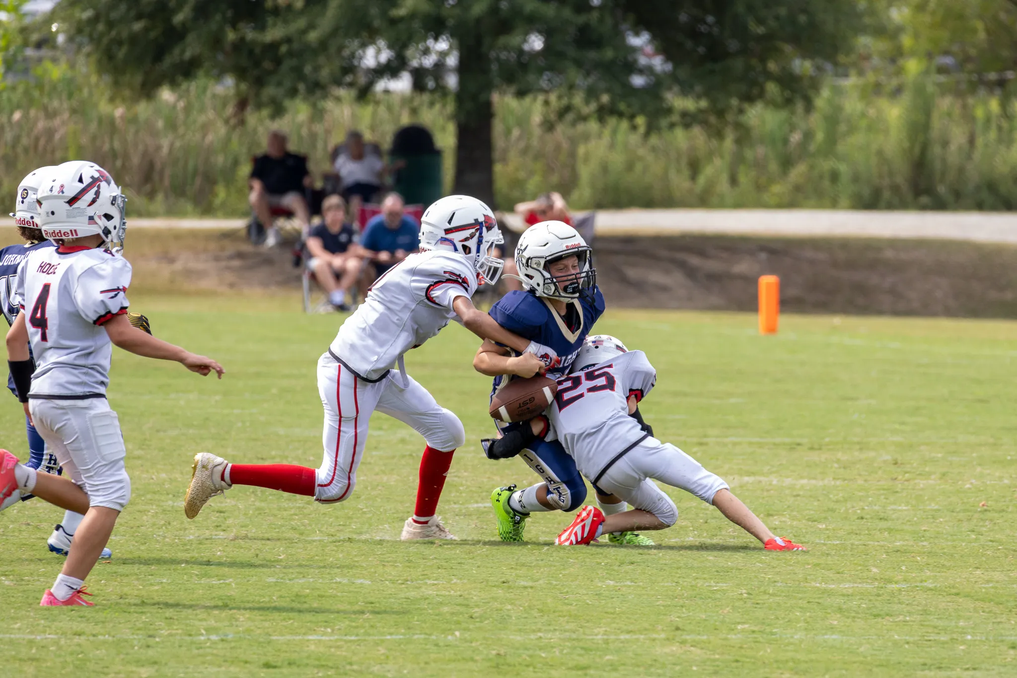 Football player getting tackled and fumbling the football