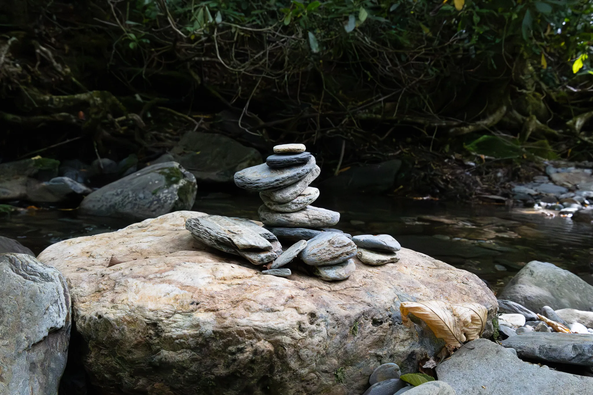 A pile of flat river stones stacked in a tower shape